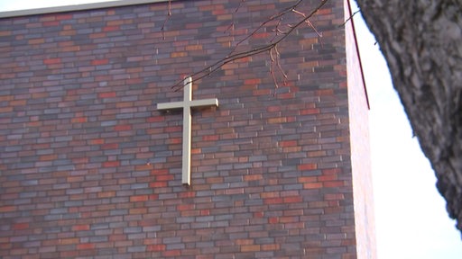 Ein Kreuz an der Fassade eines Gemeindehauses