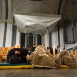 Flüchtlinge liegen auf Matrazen in einer Kirche auf dem Boden (Archivbild)
