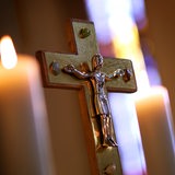 Ein Jesuskreuz und brennende Kerzen