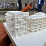 Ein Gebäude-Modell steht auf roten Backsteinen.