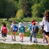 Eine Kindergartengruppe macht einen Ausflug an einen Fluss.