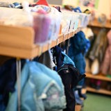 Jacken und Wechselkleidung hängen in einer Kita.