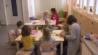 Eine Bremer Kita mit Erzieherinnen und Kindern gemeinsam am Tisch.
