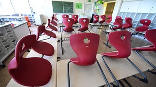 Stühle sind in einem Klassenzimmer einer Grundschule in Stuttgart auf Tische aufgereiht. In der kommenden Woche ab dem 11. September beginnt in Baden-Württemberg nach den Sommerferien das neue Schuljahr.