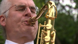 Der Bremer Musiker Klaus Fischer bespielt ein Saxophon