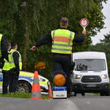Polizeibeamte stoppen einen Kleintransporter bei einer Kontrolle.