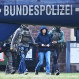 Daniela Klette wird in Handschellen zu einem Hubschrauber geführt.