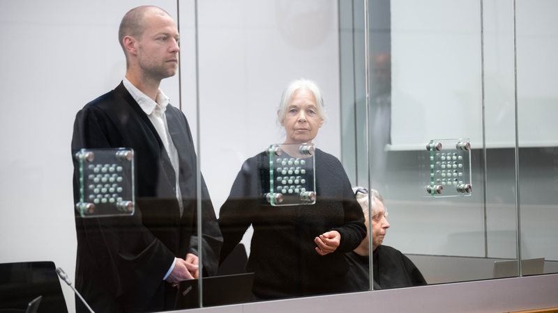 Die ehemalige RAF-Terroristin Daniela Klette steht mit ihren Anwälten Lukas Theune und Undine Weyers im Gerichtssaal vom Oberlandesgericht Celle. 