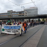 Menschen laufen bei einer Demonstration in Bremen auf einer Straße.