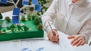Ein Architekt entwickelt eine Grünfläche mit Solarpanelen.