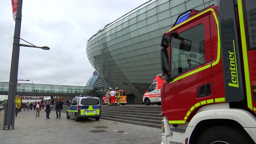 Mehrere Krankenwagen, Polizei und Feuerwehr stehen vor dem Klimahaus in Bremerhaven. 