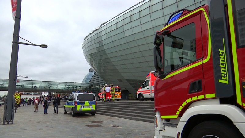 Mehrere Krankenwagen, Polizei und Feuerwehr stehen vor dem Klimahaus in Bremerhaven. 