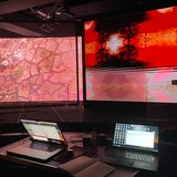 Laptops vor den Leinwänden des Klimahauses 