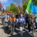 Junge Menschen gehen mit Fahnen und Schildern durch die Bremer Innenstadt.