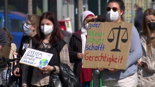 Demonstrantinnen auf der Klimastreik-Demo mit selbstgemachten Plakaten in den Händen.