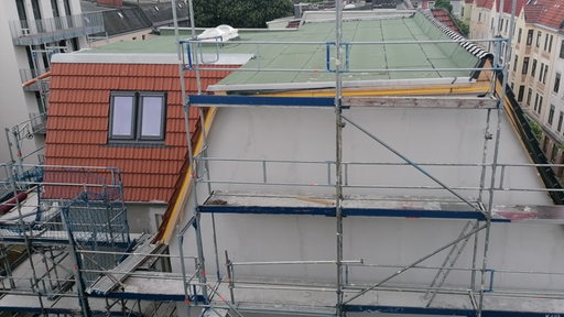 Ein Gerüst ist an einem Dach angebracht.