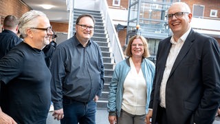 Florian Pfeffer, Björn Fecker, Kristina Vogt und Andreas Bovenschulte stehen zusammen und lachen.