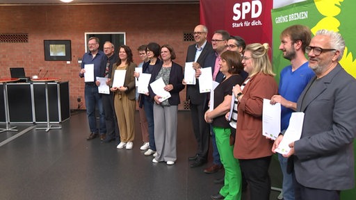 Die drei Parteien der Koalition posieren gemeinsam mit unterschriebenem Vertrag in den Händen.