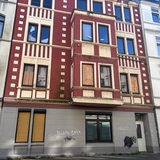 Blick auf ein rotes Mehrfamilienhaus.