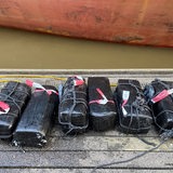 Das Bild zeigt sechs schwarze Blöcke, an die Schiffstau und Absperrband gebunden sind.