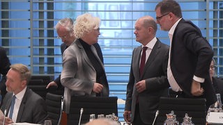 Der Bundeskanzler Olaf Scholz unterhält sich mit anderen Politikern im Bundeskanzleramt.  
