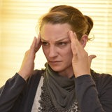 Eine Frau greift sich an die Schläfen (Symbolbild)