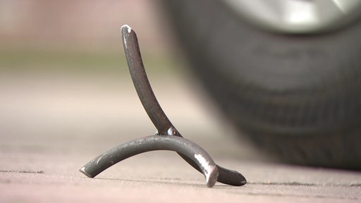 Ein sogenanter Kraehenfuss neben einem Autoreifen