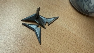 Auf einem Tisch liegen spitze Metallteile, sogenannte Krähenfüße.