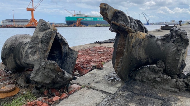 Geborgene Trümmerteile eines Pollers auf der Lloyd-Werft. Im Hintergrund ein umgestürzter Kran