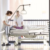 Krankenschwestern schieben einen Patientin durch das Krankenhaus. 