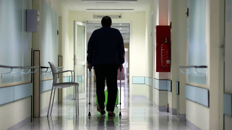 Ein Mann läuft über den Flur eines Krankenhauses.