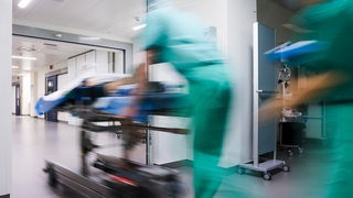 Ein Bild mit starker Bewegungsunschärfe: Ein Patient wird in den OP-Saal gebracht.