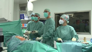 Ärzte in grünen Kitteln im Krankenhaus Links der Weser bei einer Operation.
