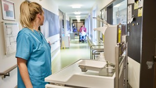 Eine medizinische Fachkraft steht in einem Krankenhausflur.