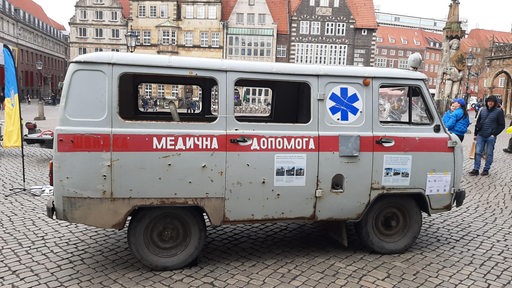 Ein Krankenwagen mit Einschusslöchern aus der Ukraine steht auf dem Bremer Marktplatz.