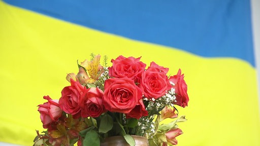 Ein Blumenstrauß vor einer Ukraine-Flagge