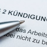 Auf einem Zettel steht Kündigung. Daneben ein blauer Kugelschreiber.