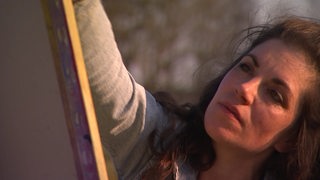 Die Künstlerin Jana Goble Soujon malt ein Bild.