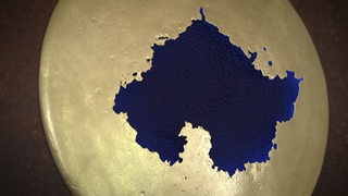Ein Kunstwerk aus altem Schrott in goldener und blauer Farbe.