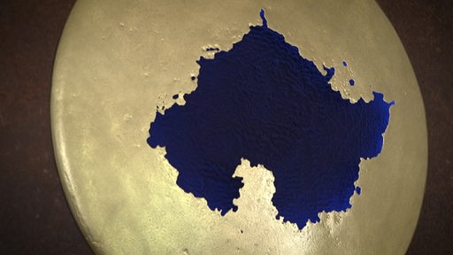 Ein Kunstwerk aus altem Schrott in goldener und blauer Farbe.