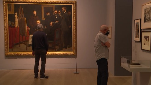 Zwei Besucher der Kunsthalle zwischen ausgestellten Gemälden.