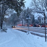 Autos sind auf der verschneiten Kurfürstenallee unterwegs.