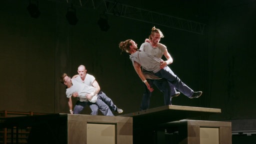 Vier Personen bei der Inszenierung einer Akrobatik-Show.