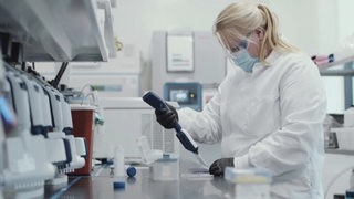 Eine Frau in Schutzkleidung im Labor.