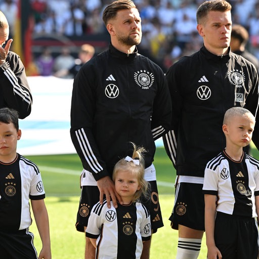 Nationalspieler Niclas Füllkrug steht bei der Hymne vor dem Länderspiel in Bremen mit seiner Tochter neben seinen Mitspielern.