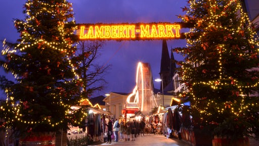 Eingangsbereich des Lamberti-Marktes in Oldenburg mit zwei großen geschmückten Tannenbäumen und einem leuchtenden Schriftzug.