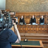 Richter stehen am Tisch vor Verhandlungsbeginn.