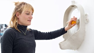 Laura Pientka an ihrer Installation in der Ausstellung "Leck mich am Arsch" in der Städtischen Galerie