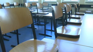Eine leere Schulklasse, in der die Stühle hochgestellt sind.