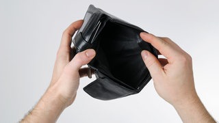 Zwei Hände halten ein leeres Portemonnaie